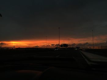 Cars on road against sky during sunset