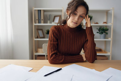 Portrait of young woman working at desk in office