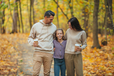 Full length of father with daughter against trees during autumn