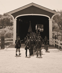 Rear view of people standing against building