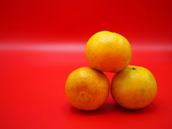 Close-up of oranges against red background