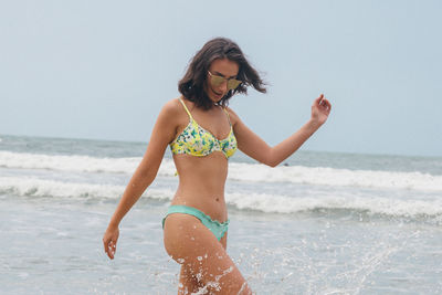 Full length of woman on beach against clear sky