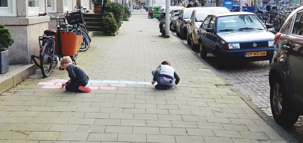 REAR VIEW OF PEOPLE ON STREET