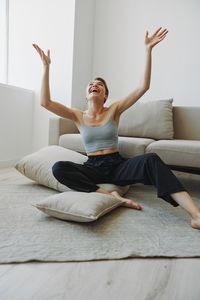 Young woman sitting on bed at home