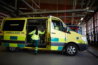 Female paramedic getting in ambulance at parking lot