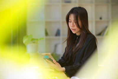 Portrait of young woman using laptop at home