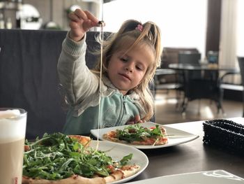 Girl holding food on table