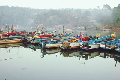 Boats moored in lake against sky