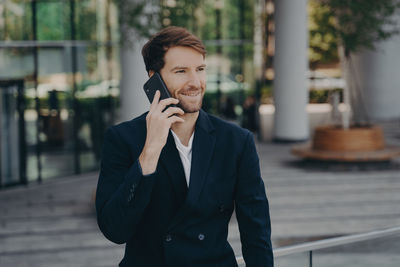 Young man using mobile phone outdoors