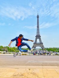 Full length of man jumping against eiffel tower