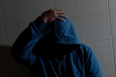 Midsection of man standing against wall