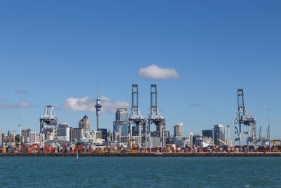 Boats in sea against clear blue sky