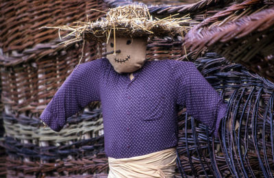 Close-up of scarecrow by whicker baskets