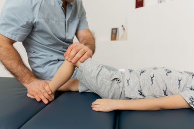 Knee pain relief in clinic. doctor physiotherapist doing healing treatment on patient leg. 