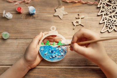 Cropped hands of woman holding toy on table