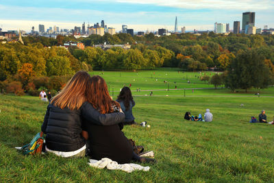 People sitting on grass at city park