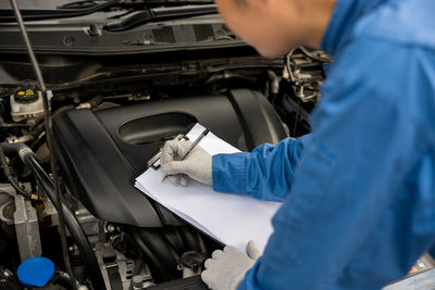 Midsection of man repairing car