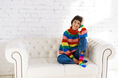 Young woman sitting on sofa at home