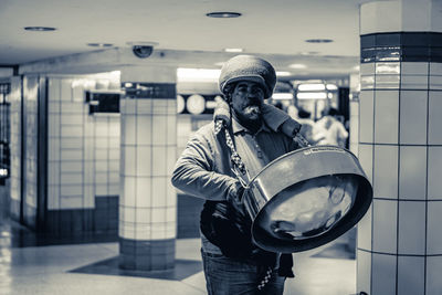 Man playing musical instrument in subway