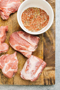 Pork shoulder and dry rub spices on cutting board still life