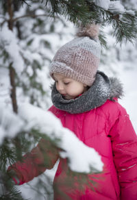 Boy in snow covered tree