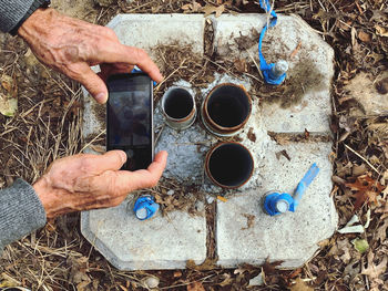 A man taking photo of street lights hole that was broken.