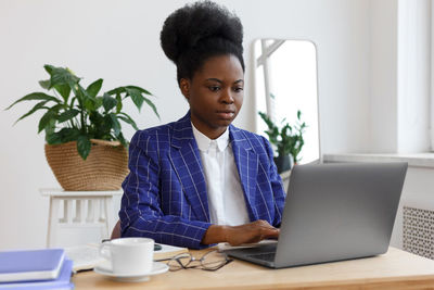 Businesswoman using laptop at office