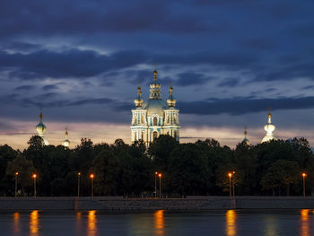 Illuminated buildings against sky at dusk