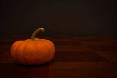 Close-up of pumpkin on table against black background