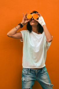 Full length of man standing against orange wall