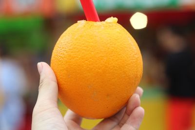 Close-up of hand holding orange