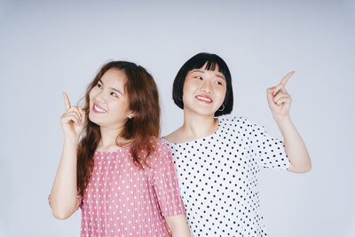 Portrait of a smiling young woman against white background