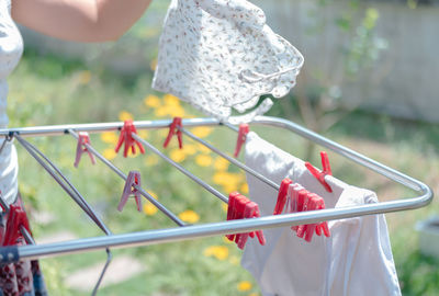 Cropped image of woman picking clothes from laundry rack