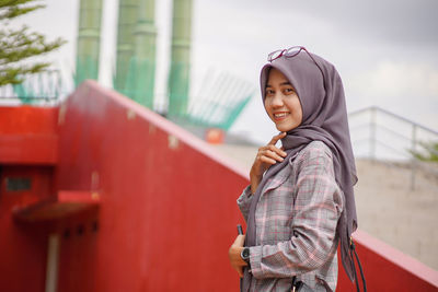 Portrait of young woman standing in city