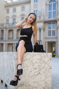 Portrait of young woman standing in city