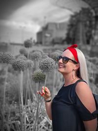 Portrait of young woman wearing sunglasses standing outdoors