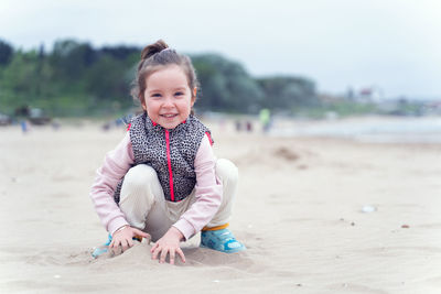 Portrait of cute boy sitting on beach