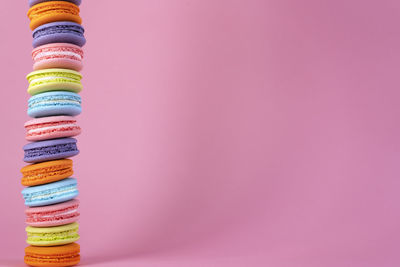 Delicious colorful french macaroons on pink background. copy space. selective focus.