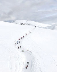 High angel view of person walking on snow covered land against sky