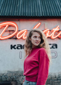 Portrait of woman standing against wall