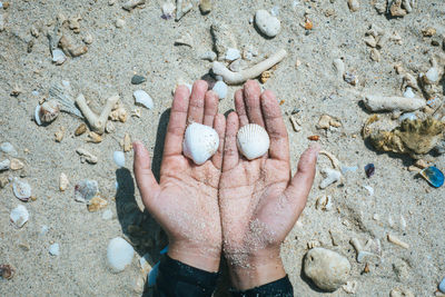 High angle view of human hand on sand