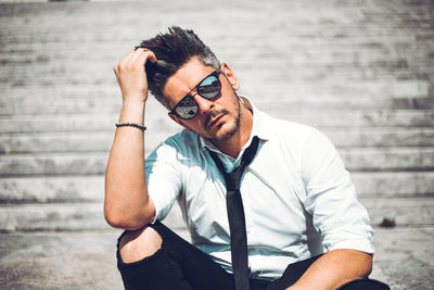 Midsection of man wearing hat while standing against wall