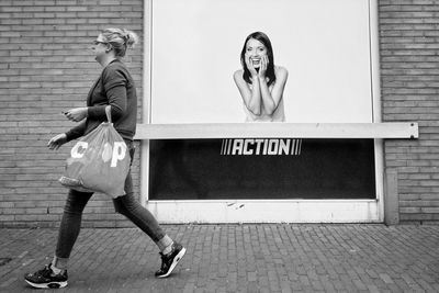 Portrait of woman standing against wall