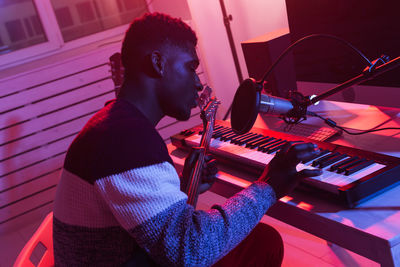 Side view of young man sitting on stage