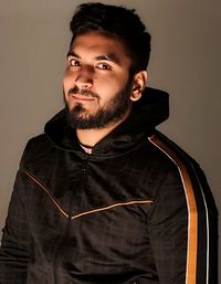 Portrait of young man standing against wall