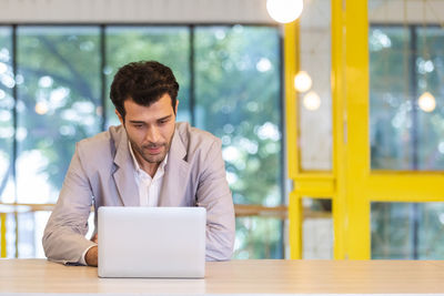 Man looking at camera while sitting on table