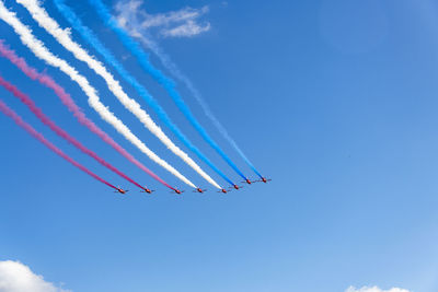 Low angle view of airplane flying against blue sky