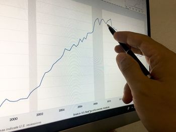 Cropped hand of person making graph on digital tablet