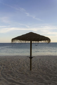 Beach umbrella on the sand with ocean on the background