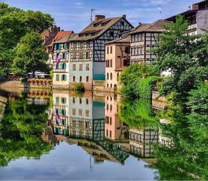 Buildings by lake against sky